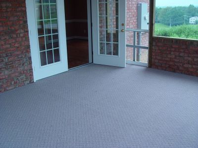 long screened porch with carpet and brick